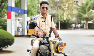 Traffic police officer Naveen Singh recording a moto vlog during a road stop, capturing real-time traffic interaction and road safety awareness through a helmet-mounted camera.
